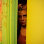 Last Year: Cassidy (Genevieve DeGraves) looks through her chained door. 
Photo by Keri Anderson for Shaftesbury  
Copyright: Shaftesbury 
