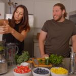 Carlos Parisi and Lauren Cornell in the kitchen juicing oranges