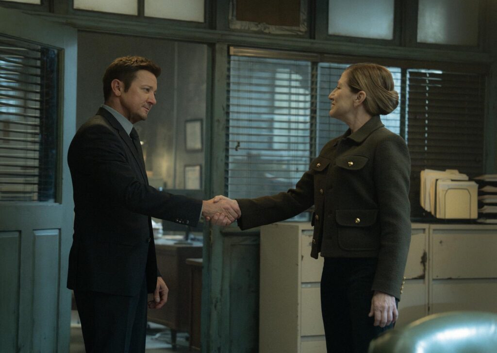 MOK_401_DPM_0206_0131_RT L-R: Jeremy Renner as Mike McLusky and Edie Falco as Nina Hobbs in Mayor of Kingstown season 4, streaming on Paramount+, 2025. Credit: Dennis P. Mong Jr./Paramount+ ©2025 Viacom International Inc. All Rights Reserved. Mayor of Kingstown and all related titles, logos and characters are trademarks of Viacom International Inc.