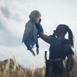 (L-R) Thia (Elle Fanning) and Dek (Dimitrius Schuster-Koloamatangi) in 20th Century Studios' PREDATOR: BADLANDS film. Photo courtesy of 20th Century Studios. © 2025 20th Century Studios. All Rights Reserved.